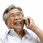 高齢者が携帯電話で会話をしている写真
